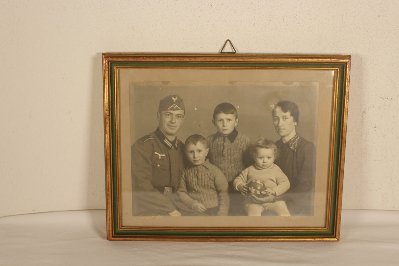 Foto da studio in cornice d'epoca, raffigurante un soldato della Heer con famiglia.